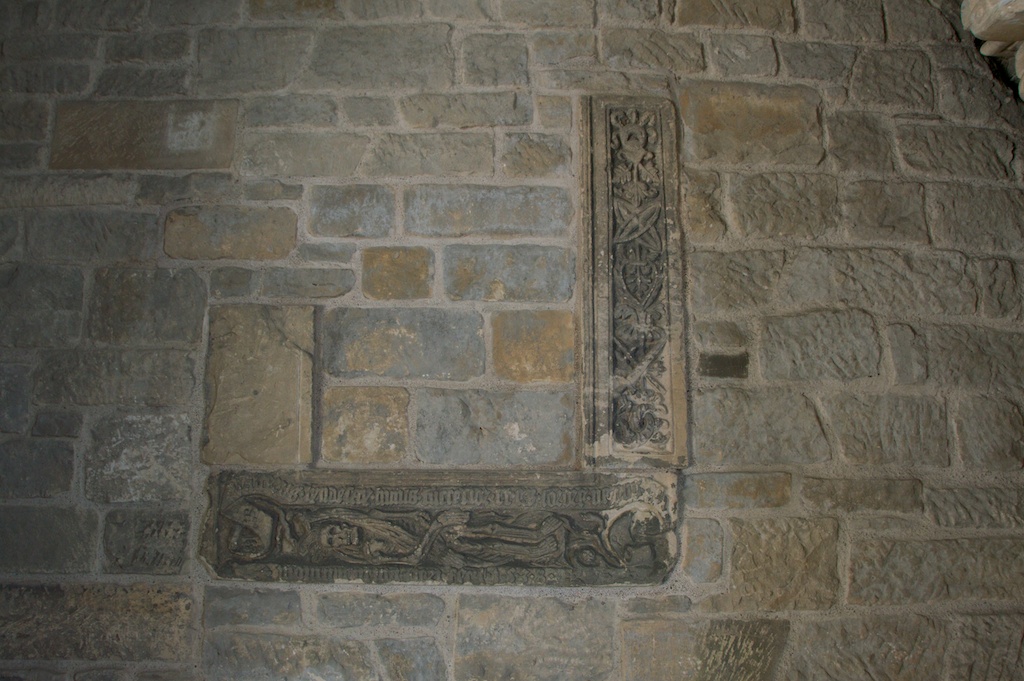 Old carvings incorporated in walled-up nave arch